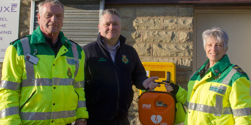 Rossendale community group celebrate huge milestone and smile to camera with defobrillator.