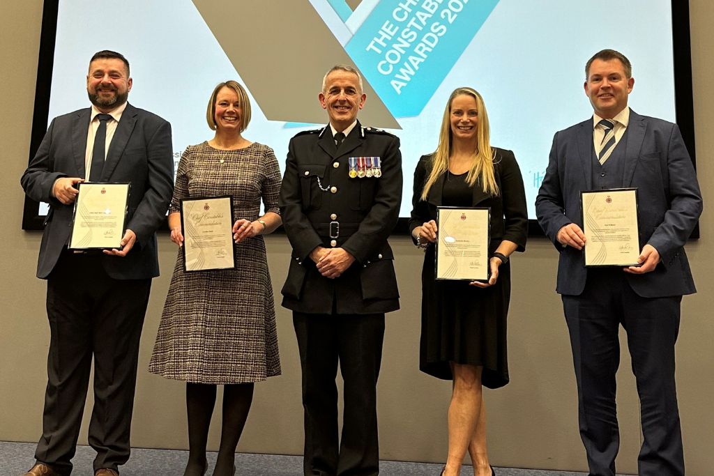 A group of people standing on a stage smiling with their certificates