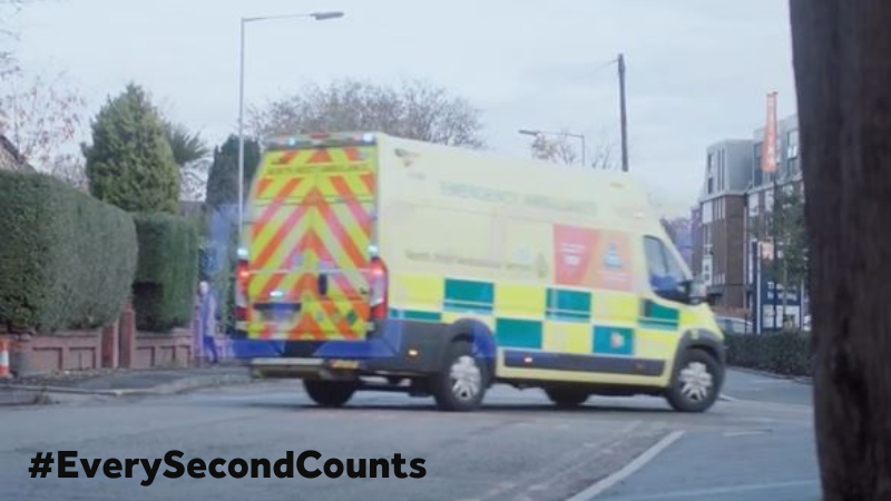 An emergency ambulance turning into a road.