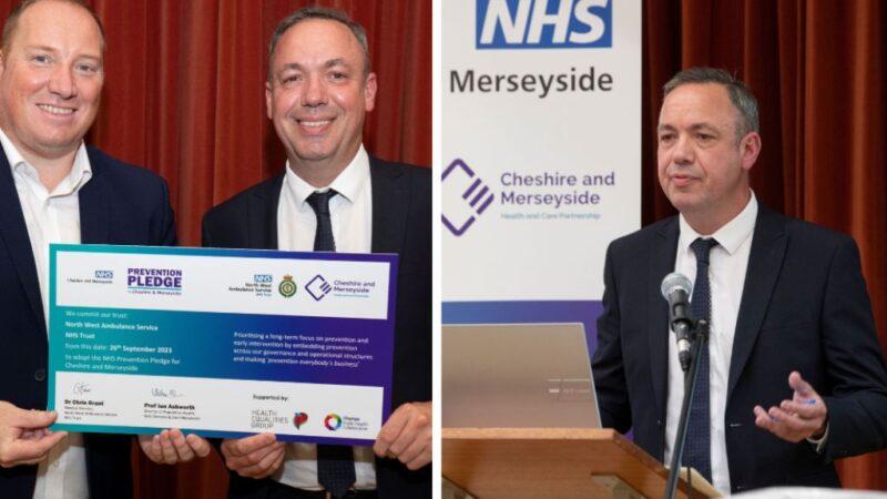 A photo of two men smiling with pledge certificate besides a man in a suit holding a speech.