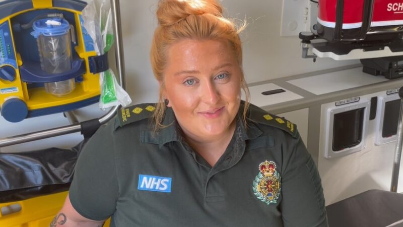 A female paramedic smiling in an ambulance